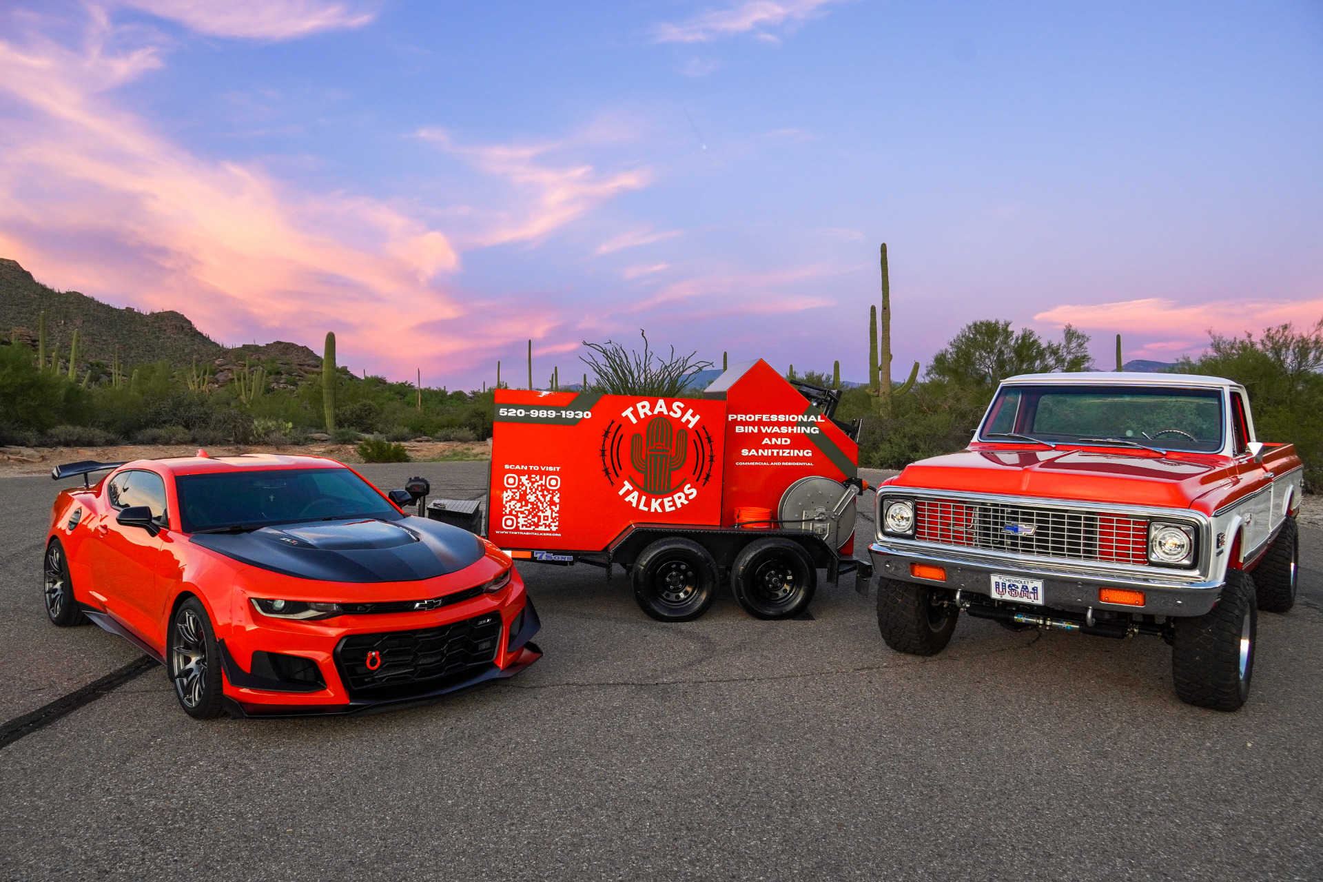The Trash Talkers fleet — crush orange bin cleaning trailer flanked by the crew's Camaro and classic Chevy pickup in the Tucson desert